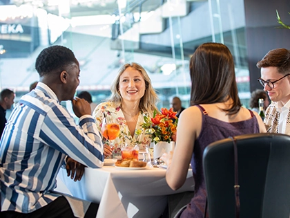 A group of people dine in the Committee Room by Grossi at the MCG