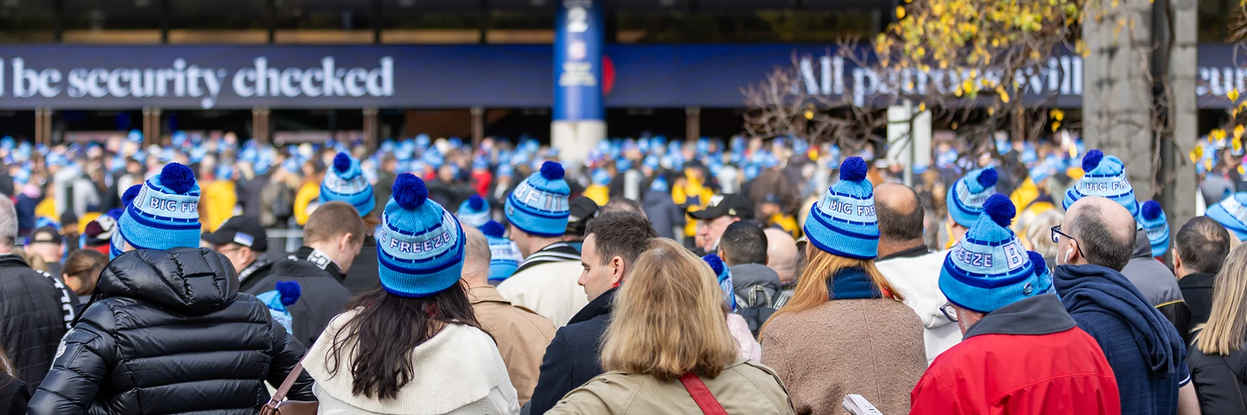 Crowd in blue Big Freeze beanies outside MCG Gate 2 in winter