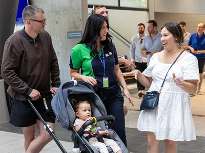 Family with a pram in conversation with stadium staff member