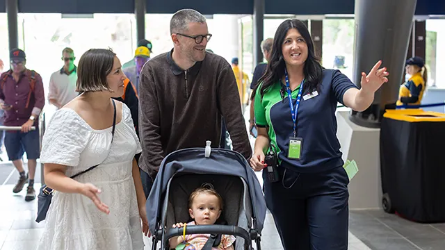 Stadium staff helps direct a family with a pram