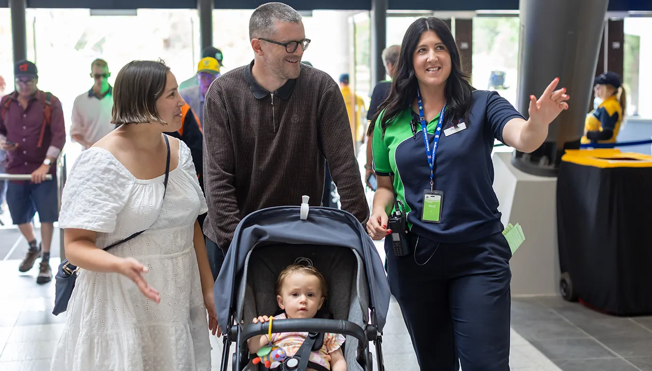 Stadium staff helps direct a family with a pram