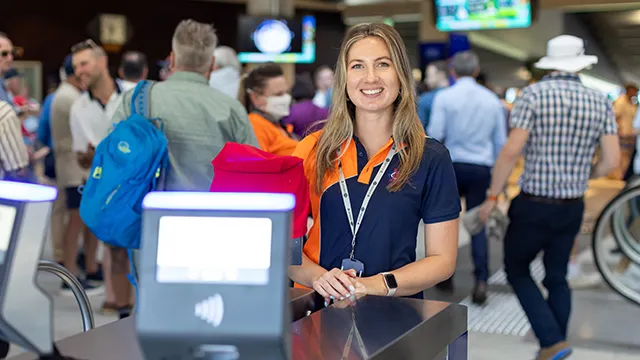 MCC staff member welcomes patrons at ticket gate