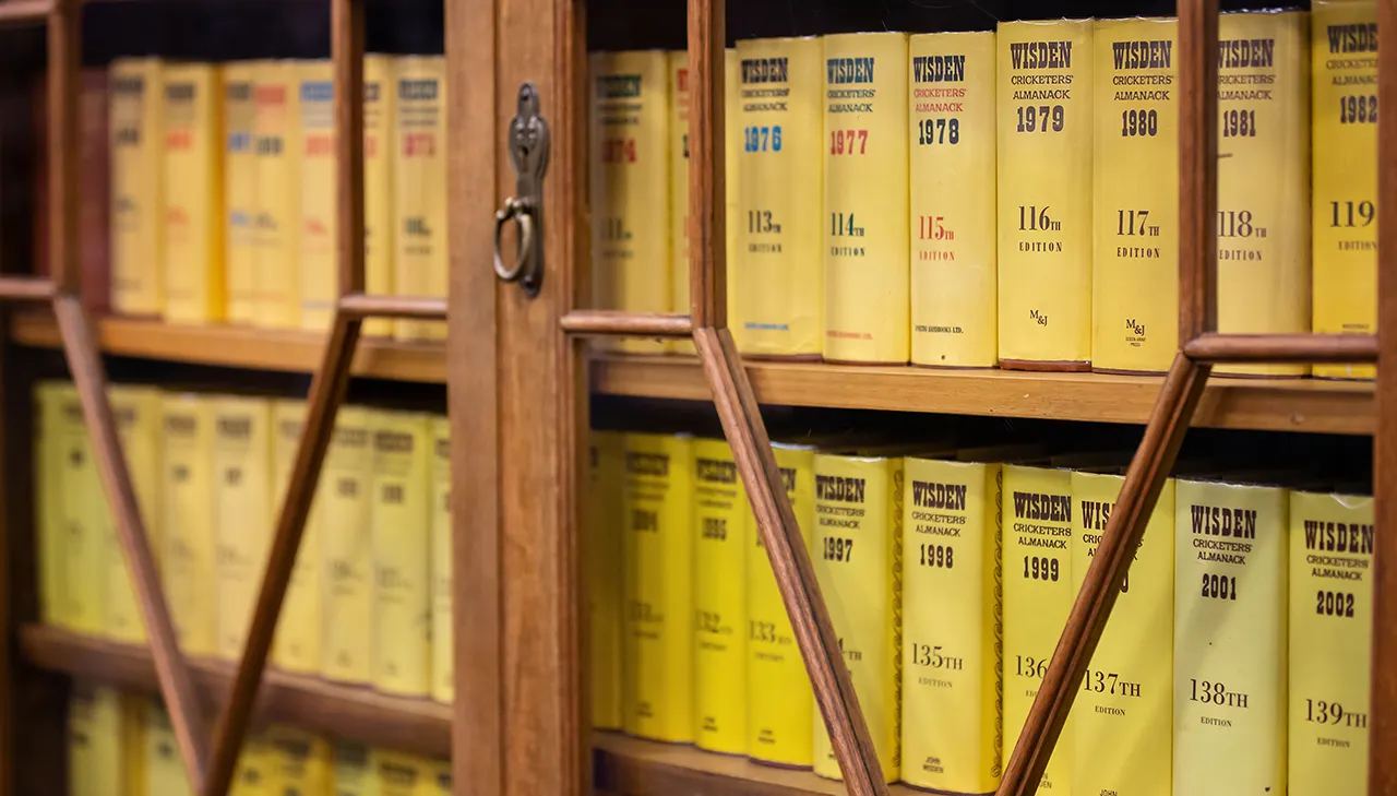 Display case with Cricketers' Almanac books from 1900s