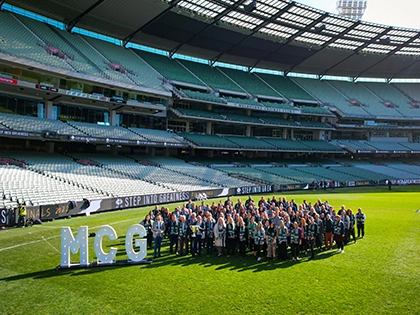 MCC staff stand in the group on the MCG arena