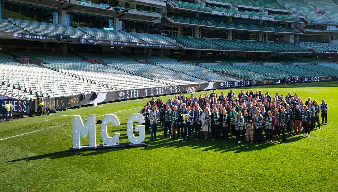 MCC staff stand in the group on the MCG arena