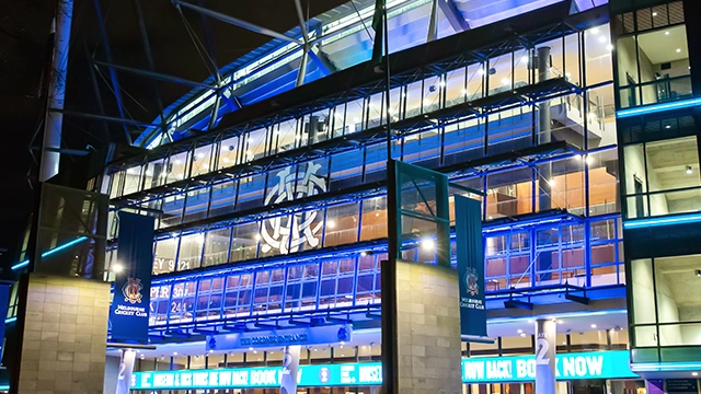 Gate 2 of the MCG lit up in blue at night