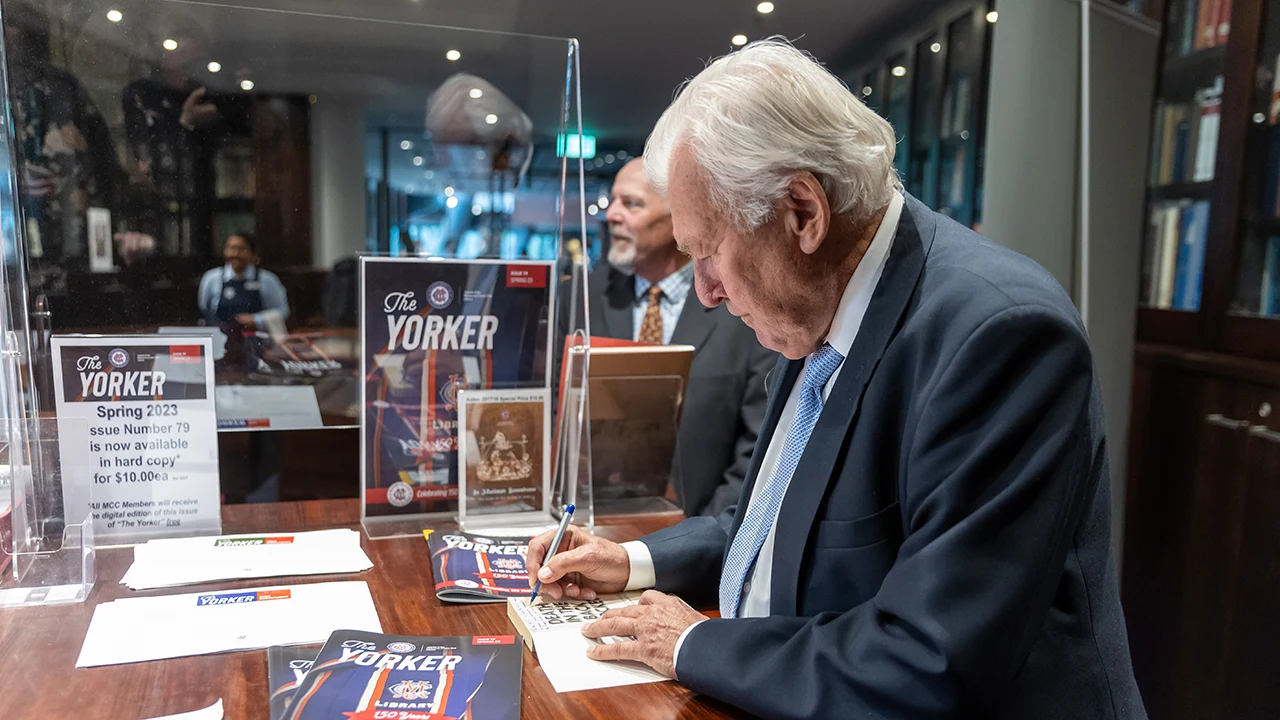 Signing books next to The Yorker display in the MCC Library