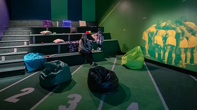 Inside sensory space with beanbags, pillows, fidgets, tiered seating and cinema lighting.