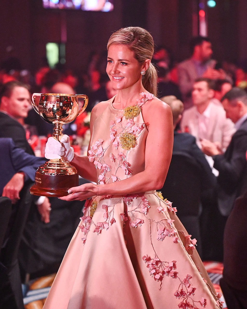 Michelle Payne holding the Melbourne Cup at a formal ceremony