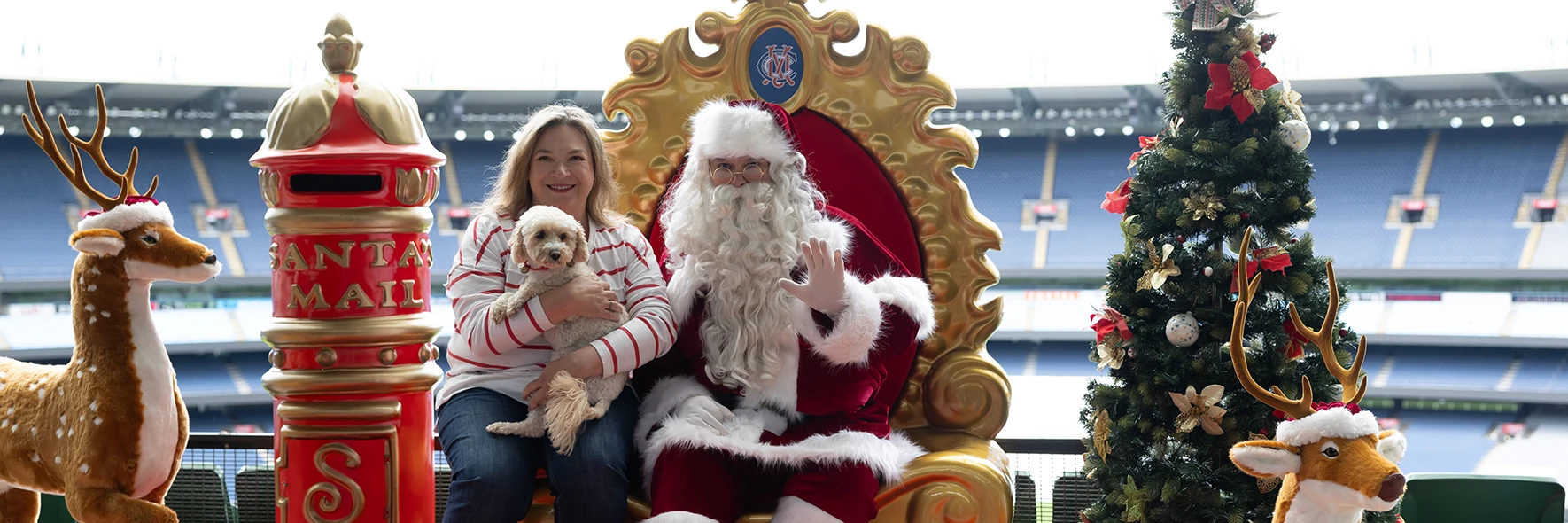 Woman holding her dog while posing with Santa at the MCG